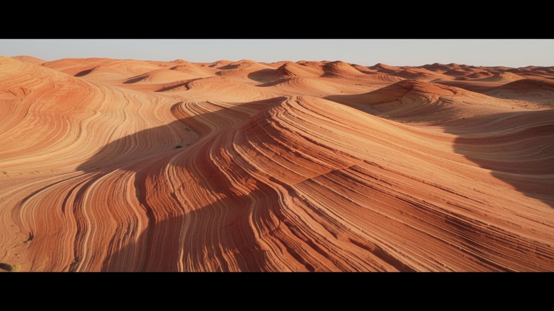 Dunes de désert rocheux, textures sculptées par le vent, tons chauds, fond d'écran minimaliste