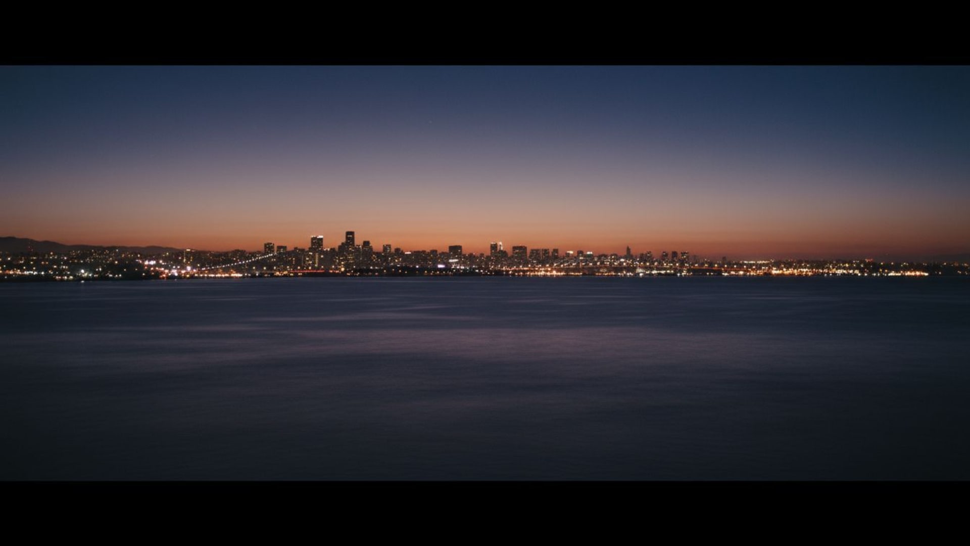 Océan cinématographique nuit horizon lumières ville silhouette humeur tranquille douceur